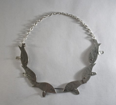 Necklace designed to look like multiple fish. Zoe Prekop crafted it in Metalsmithing to later on submit to an art show. This piece won her a scholarship.