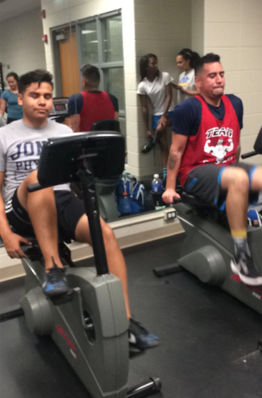Israel Reyez '16 and Art Teacher Gaberiel Dominguez work on cardio at the former classroom turned fitness center in the north building.