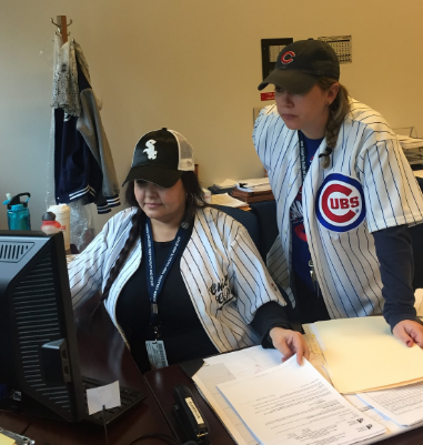 Meredith Kramer (R) and Erma Gamboa (L) wear their team jerseys in the office.