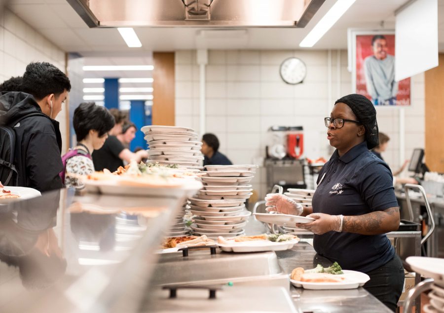 Cafeteria workers greet students, starting as early as the morning breakfast.