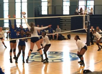 Jill Kavalauskas '18 tips the volleyball over Lincoln Park’s blockers, scoring a point and further widening the lead during Tuesday night’s blowout against Lincoln Park.