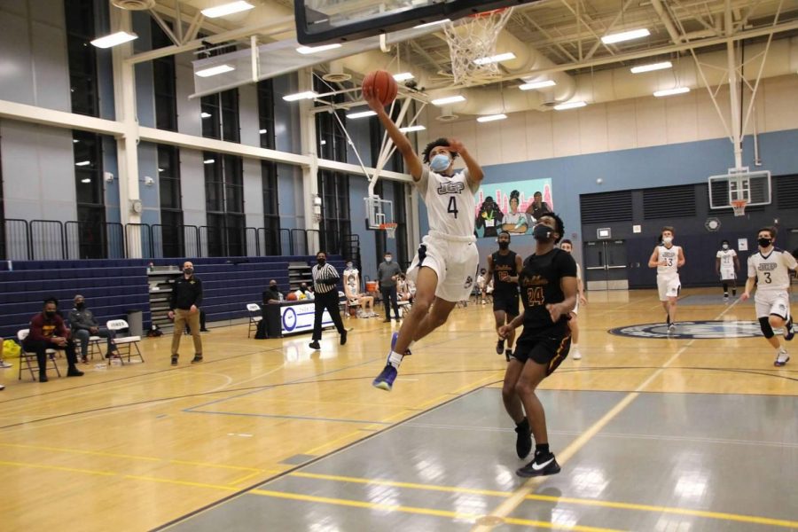 BASKETBALL COVID-19 STYLE Devin Boston ‘22 goes for a layup at the Eagle Nest.