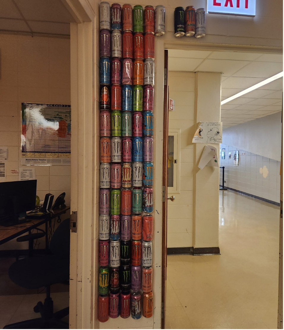 A wall decorated with Monster Energy drinks outside of Jeanette Jakupi’s classroom. Mattea Battle, a sophomore, and other students added their drinks to the wall.