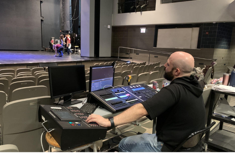 Brennan Roach sits at the control table in the theater watching the cast of “The Skin of Our Teeth” practice a scene. Roach and the cast ran act two of the play and smoothed out the bumps.